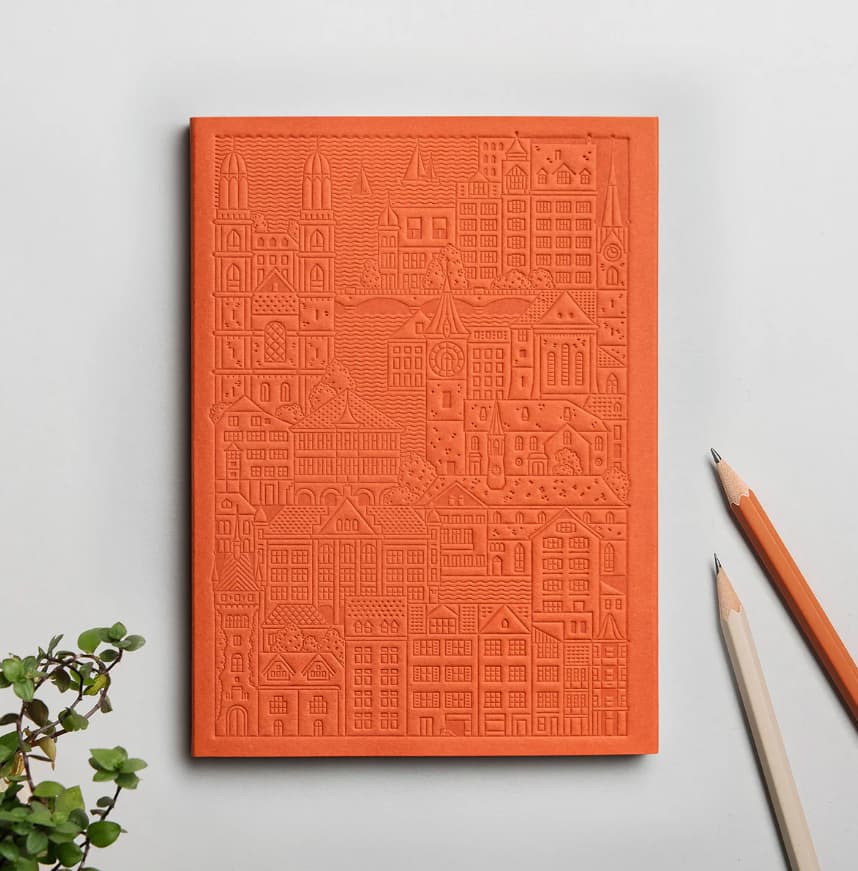 Debossed orange Zurich notebook personalised for corporate events, premium sustainable swag for clients and teams